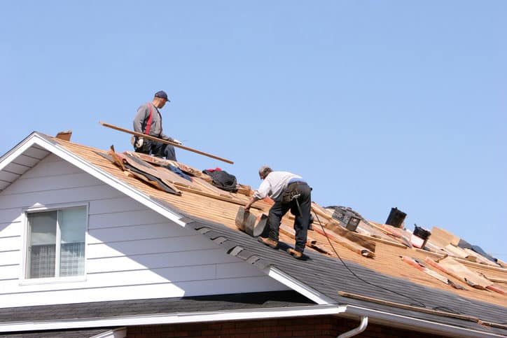 Roofers working with a blue sky background.